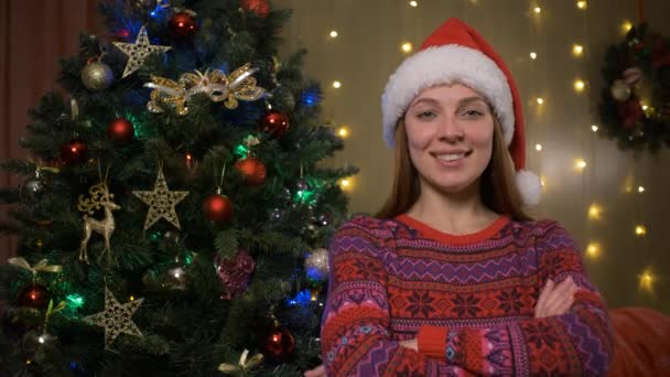 Портрет молодой женщины в шляпе Санты Счастливой и взволнованной стоя во время Рождества, Рождества на дому праздники и празднования Концепция — стоковое видео
