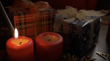 Bir kadın Noel süsleriyle mum yakıyor..
