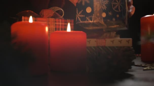 Female hands put and finalize Christmas gift on a table decorated — Stock Video