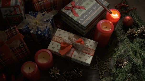 На столі, прикрашеному різдвяними прикрасами, світить свічка. — стокове відео