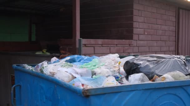 Przepełniony kosz na śmieci. Dużo śmieci na miejskiej scenie ulicznej. Pojemnik ze śmieciami musi być opróżniony. — Wideo stockowe