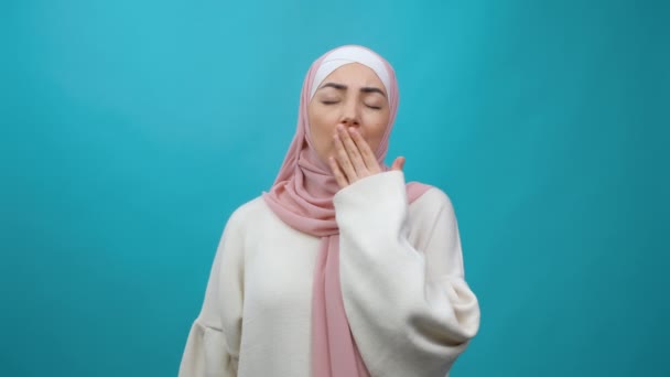 Tired cheerful excited Young Muslim woman in hijab put hand on head hold hot paper cup of coffee or tea drinking. Loss of energy, tired and desire to sleep or insomnia. Traditional Islamic culture — Stock Video