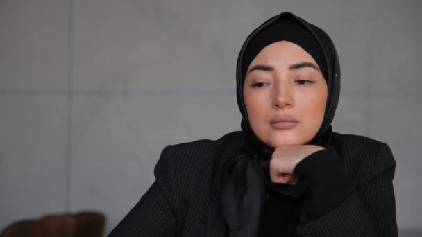 事務所で問題を解決することを考えてヒジャーブの思考の若いイスラム教徒のアラビア語の女性。カフェでの企画、研究、ブレインストーミング。伝統的なイスラム文化と宗教の概念. — ストック動画