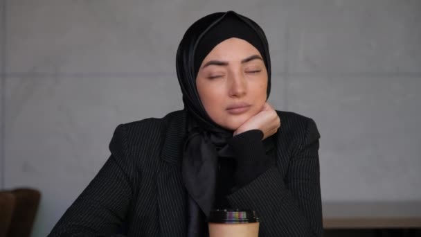 Jonge moslim vrouw in hijab drinken van thee of koffie en weg te kijken denken oplossen probleem — Stockvideo