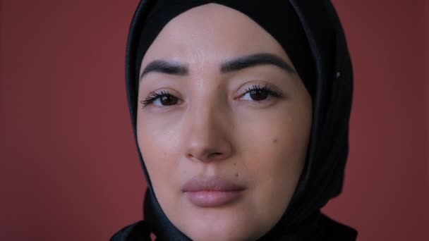 Екстремальний крупним планом портрет молодої красивої східної мусульманки в хіджабі, дивлячись на камеру і посміхаючись — стокове відео