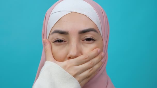 Портрет мусульманки в хиджабе, удаляющей руку изо рта и улыбающейся в камеру в изолированной студии. Равноправие, разнообразие, феминизм, раса, расизм, права человека, защита, дискриминация — стоковое видео