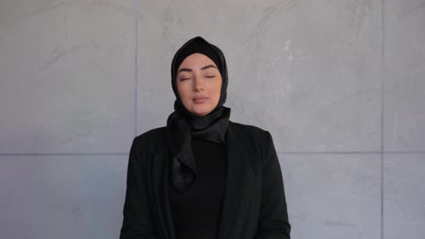 Přirozená krása. Mladá vážná muslimka, která nosí tradiční šátek, dívá se na kameru a pózuje doma. Středovýchodní arabská dáma. Tradiční islámská kultura a náboženství — Stock video