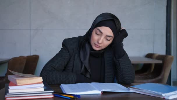 Jonge moslimvrouw in hijab is moe van het studeren. Begrip onderwijs, onderzoeksinformatie, e-learning. — Stockvideo