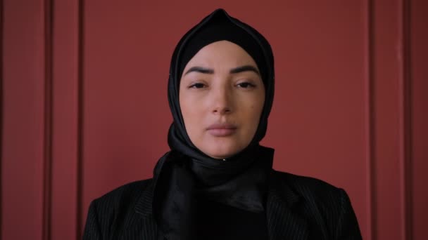 Мусульманська арабська незалежна жінка в Хіджабі дивиться на камеру. Впевнена жінка стоїть у кафе. Концепція індивідуальності людей, бізнесменка з Близького Сходу. Традиційна ісламська культура і релігія — стокове відео