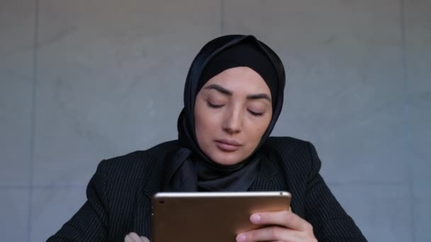 Мусульманська кусинка тримає цифрову табличку і працює, професійний план, дослідження і аналіз. Провідний проект — стокове відео