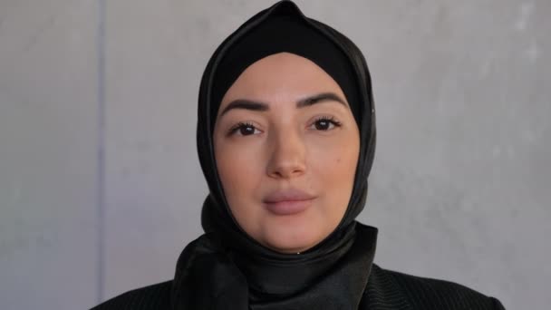 Закріпіть портрет професійної бізнесменки-мусліма, яка дивиться на камеру, усміхаючись щасливим у традиційному головному шарфі в офісі. Традиційна ісламська культура і релігія. Аравійська релігійна жінка — стокове відео
