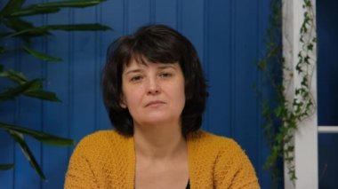 Orta yaşlı, güzel bir kadın kameraya bakıyor. Neşeli, mutlu, orta yaşlı, emekli bir kadın. Büyük anne, yakın plan portresi için poz vermekten memnun.