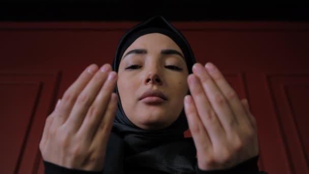 Young Muslim woman in hijab raises her hand and prays. Close-up praying namaz muslim woman. Traditional Islamic culture and religion concept. Arabian religious woman — Stock Video