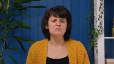 Orta yaşlı kadın odadaki kötü kokuya kaşlarını çatar. Bozuk hava