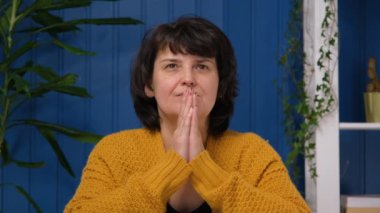 Endişeli, yalvaran orta yaşlı kadın içtenlikle dua ediyor ve yalvaran bir ifadeyle yukarı bakıyor, özür diliyor, umut dolu bir yüzle yalvarıyor. Dini umut kavramı, Katolik affı.