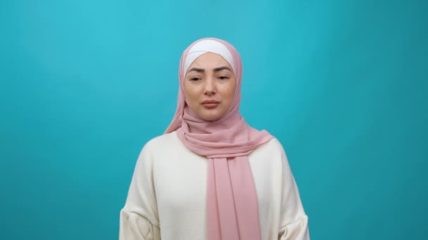 Studio terisolasi mengalami Depresi dan kesedihan, emosi negatif. Wanita muslim muda mengenakan jilbab terlihat frustrasi, merasa khawatir putus asa. pengambilan gambar studio dalam ruangan terisolasi pada latar belakang biru — Stok Video