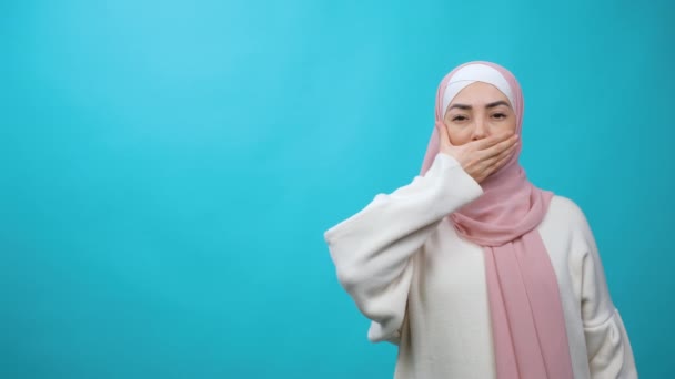 Moslimvrouw in hijab die hand uit haar mond haalt in een geïsoleerde studio. Gelijkheid, diversiteit, feminisme, ras, racisme, mensenrechten, bescherming, discriminatie — Stockvideo