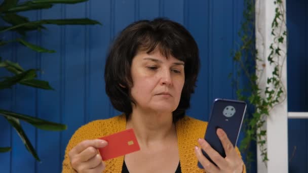 Kobieta w średnim wieku zakupy online z karty kredytowej za pomocą smartfona — Wideo stockowe