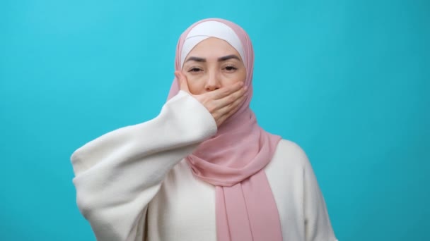 口の中で手を口にせずに表現するヒジャーブの揺れ頭の中で悲しいと深刻なイスラム教徒の女性。差別と平等の権利のための戦い。隔離されたスタジオで — ストック動画