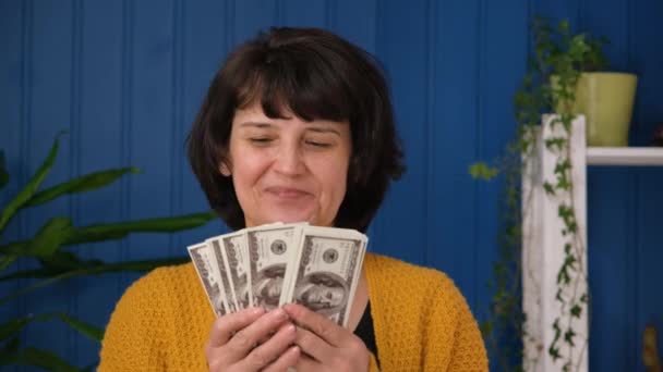 Середній вік жінка тримає в руках гроші готівкою. Жінка показує доларові банкноти. Американські гроші в жіночих руках. Успішні люди виграють у лотерею. — стокове відео