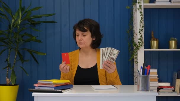 La mujer está sosteniendo la tarjeta de crédito y el dinero y elegir dinero en efectivo dólar. Concepto de finanzas, ahorro bancario, inversión — Vídeo de stock