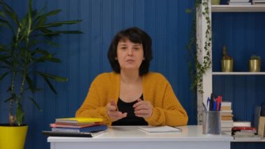 Orta yaşlı bir kadın video görüşmesinde konuşuyor. Çevrimiçi öğretmen kavramına sahip uzaklık eğitimi.