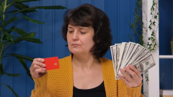 Frau mittleren Alters hält Kreditkarte und Geld und wählt Bargeld Dollar. Finanzierungskonzept, Banksparen, Kundenservice, Investition — Stockvideo