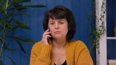 Orta yaşlı bir kadın telefonda kötü bir haber duydu ve şok oldu. Üzgün ve üzgün yalnız kadın depresyonda. İflas kavramı, hastalık, olumsuz teşhis
