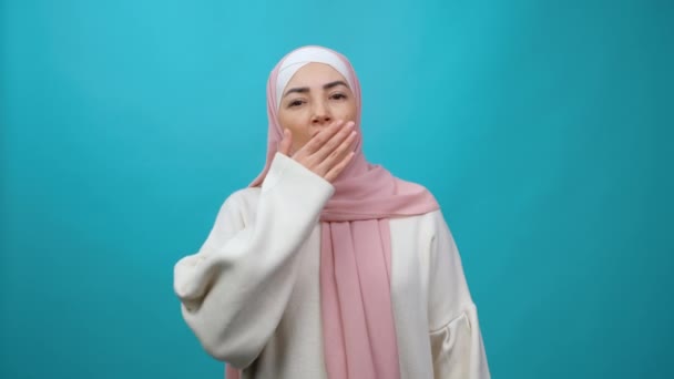 Mujer musulmana joven agotada en hiyab bostezando ampliamente, con aspecto somnoliento y somnoliento, estirando las manos para despertarse temprano en la mañana, insomnio y falta de energía. Grabación de estudio aislada — Vídeos de Stock