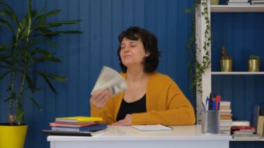 Dolar banknotları sallayan orta yaşlı bir kadın. Amerikan parası kadınların elinde. Başarılı insanlar piyango kazanır alışveriş yapar şans kazanır.