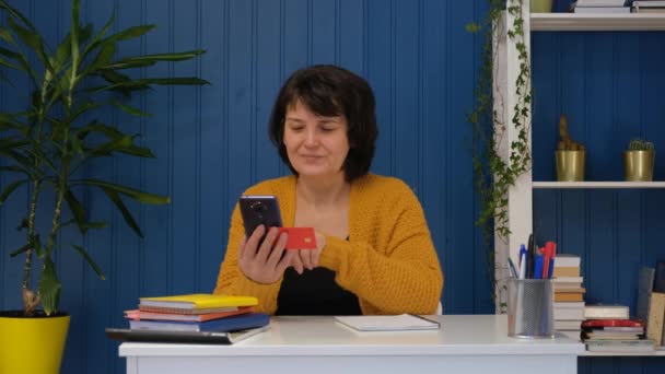 Mujer de mediana edad usando tarjeta de crédito para compras en línea — Vídeo de stock