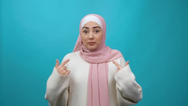 Wow, du wählst mich. Überraschte junge Muslimin im Hidschab, die sich zeigt und erstaunt schaut, schockiert über den Erfolg, eine unglaubliche Leistung. Einzelne Studioaufnahmen — Stockvideo