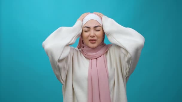 Mal de tête. Fatigué déprimé bouleversé Jeune femme musulmane dans le hijab se sentant en mauvaise santé, souffrant de migraine et de tension insupportable, méningite, symptôme de grippe. intérieur isolé — Video