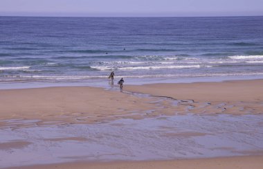 Coto Plajı (Lugo, İspanya), 23 Ekim 2021. Cantabrian Denizi sahilinde sörfçüler. Çok güzel bir doğa ve çok az turistin bulunduğu bir alandır, su sporları için çok iyidir.. 
