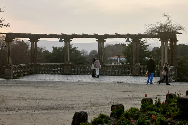 Pergola. Several people talk under the pergola of a park