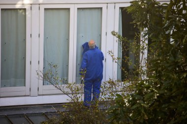 Temizlik kristalleri. Bir binanın camlarını temizleyen adam.