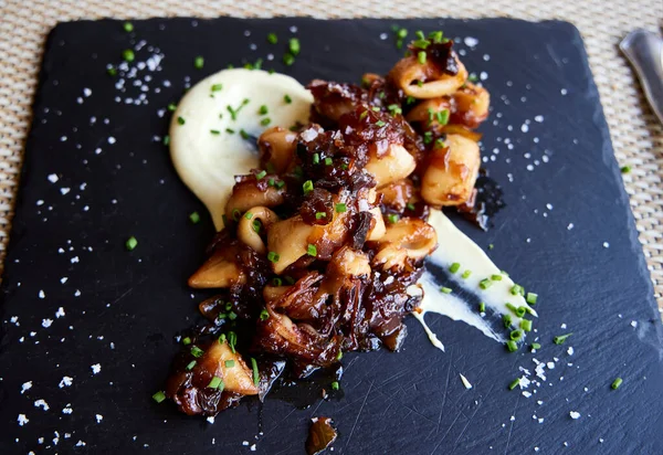 mürekkep balığı. Kalamar, karamelli soğan ve kişniş tabağı..