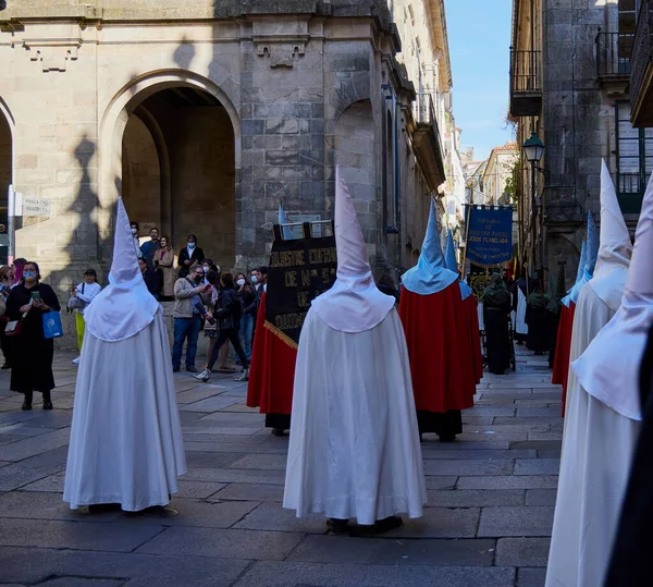 Santiago de Compostela, İspanya (9 Nisan 2022). Kutsal hafta, İspanya 'daki en ciddi kutlamalardan biridir. Hıristiyanlar ya da kardeşlikler dini imgeler taşıyan kapüşonlularla sokaklarda dolaşıyorlar.