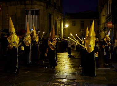 Santiago de Compostela, İspanya (11 Nisan 2022). Kutsal hafta, İspanya 'daki en ciddi kutlamalardan biridir. Hıristiyanlar ya da kardeşlikler dini imgeler taşıyan kapüşonlularla sokaklarda dolaşıyorlar.