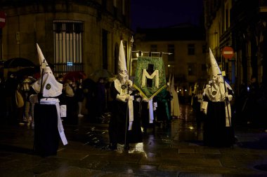 Santiago de Compostela, İspanya (11 Nisan 2022). Kutsal hafta, İspanya 'daki en ciddi kutlamalardan biridir. Hıristiyanlar ya da kardeşlikler dini imgeler taşıyan kapüşonlularla sokaklarda dolaşıyorlar.