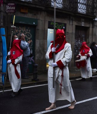Santiago de Compostela, İspanya (12 Nisan 2022). Kutsal hafta, İspanya 'daki en ciddi kutlamalardan biridir. Hıristiyanlar ya da kardeşlikler dini imgeler taşıyan kapüşonlularla sokaklarda dolaşıyorlar.