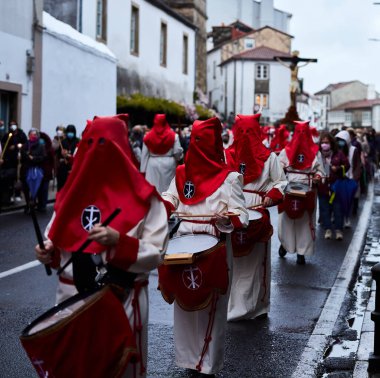 Santiago de Compostela, İspanya (12 Nisan 2022). Kutsal hafta, İspanya 'daki en ciddi kutlamalardan biridir. Hıristiyanlar ya da kardeşlikler dini imgeler taşıyan kapüşonlularla sokaklarda dolaşıyorlar.