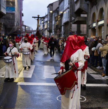 Santiago de Compostela, İspanya (12 Nisan 2022). Kutsal hafta, İspanya 'daki en ciddi kutlamalardan biridir. Hıristiyanlar ya da kardeşlikler dini imgeler taşıyan kapüşonlularla sokaklarda dolaşıyorlar.