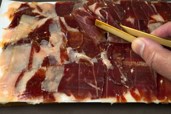Iberian Ham Man Hand Taking Some Wooden Tongs Plate Iberian — стоковое фото