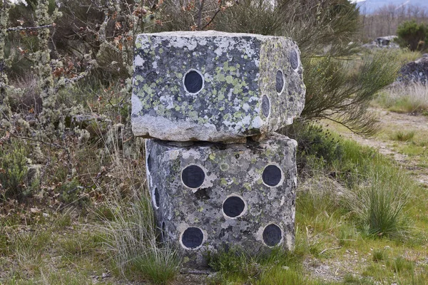 La Alberca (İspanya), 3 Mayıs 2022. Taş zarlar. Boyalı noktalı iki küp taş parçası. Bir orman yolunun yanındalar.