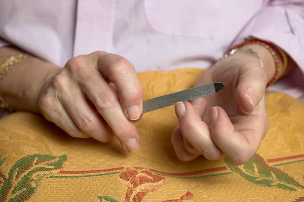 Female manicure. Woman\'s hands with a file, filing her nails