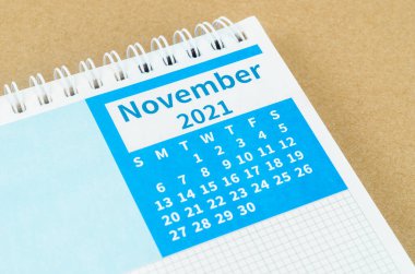 Kahverengi arkaplandaki Kasım 2021 masa takvimini kapat.