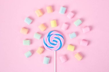 Renkli şekerlemeler ve pembe arka planda tatlı şekerler..