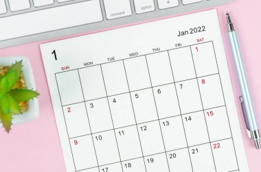 Pembe zemin üzerinde klavye bilgisayarı olan Ocak 2022 takvim sayfası.