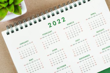 Tahta arka planda 12 aylık masa takvimi 2022.